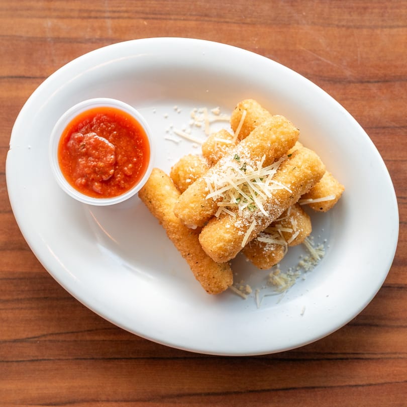 Golden-brown mozzarella sticks, sprinkled with Parmesan and herbs, served with a side of marinara sauce.
